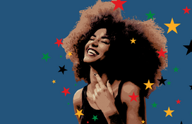A light skinned Black woman with an afro wearing a black tank top smiles joyfully. 