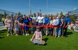  County Executive Calvin Ball posed with fellow elected officials, Department of Recreation & Parks staff members, and community members about to the cut the red ribbon to mark the opening of the amenities at Blandair Regional Park's west area.