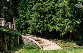 Stone staircase at Longwood Gardens with pine trees in the background.