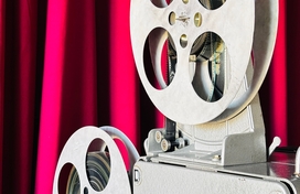 film projector in front of red curtain