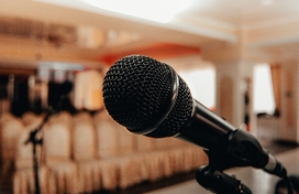 closeup of microphone in the foreground with empty seating in the background