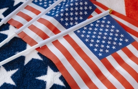 three smaller American flags on top of a larger American flag