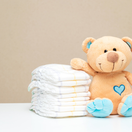 stack of diapers and a teddy bear