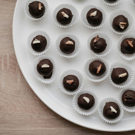Tray filled with chocolate truffles in paper baking cups.