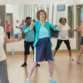 Group of women participating in fitness class inside.