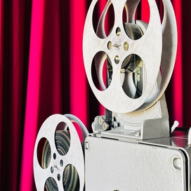 film projector in front of red curtain