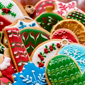 an assortment of holiday cookies in reds and greens and blues and whites shaped like gingerbread people, snowflakes, mittens, and candy canes