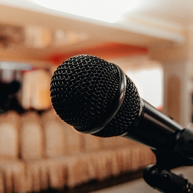 closeup of microphone in the foreground with empty seating in the background