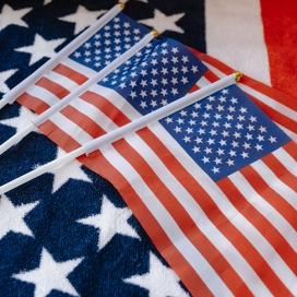 three smaller American flags on top of a larger American flag
