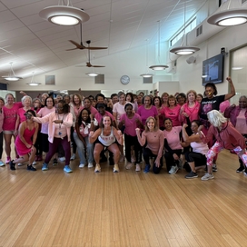 group of women posing in their pink workout clothing